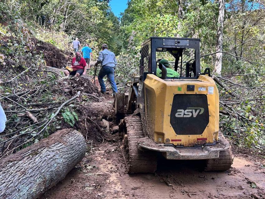 Debris removal Machinery removing downed trees in road