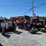 People lined up at tractor trailers loaded with food