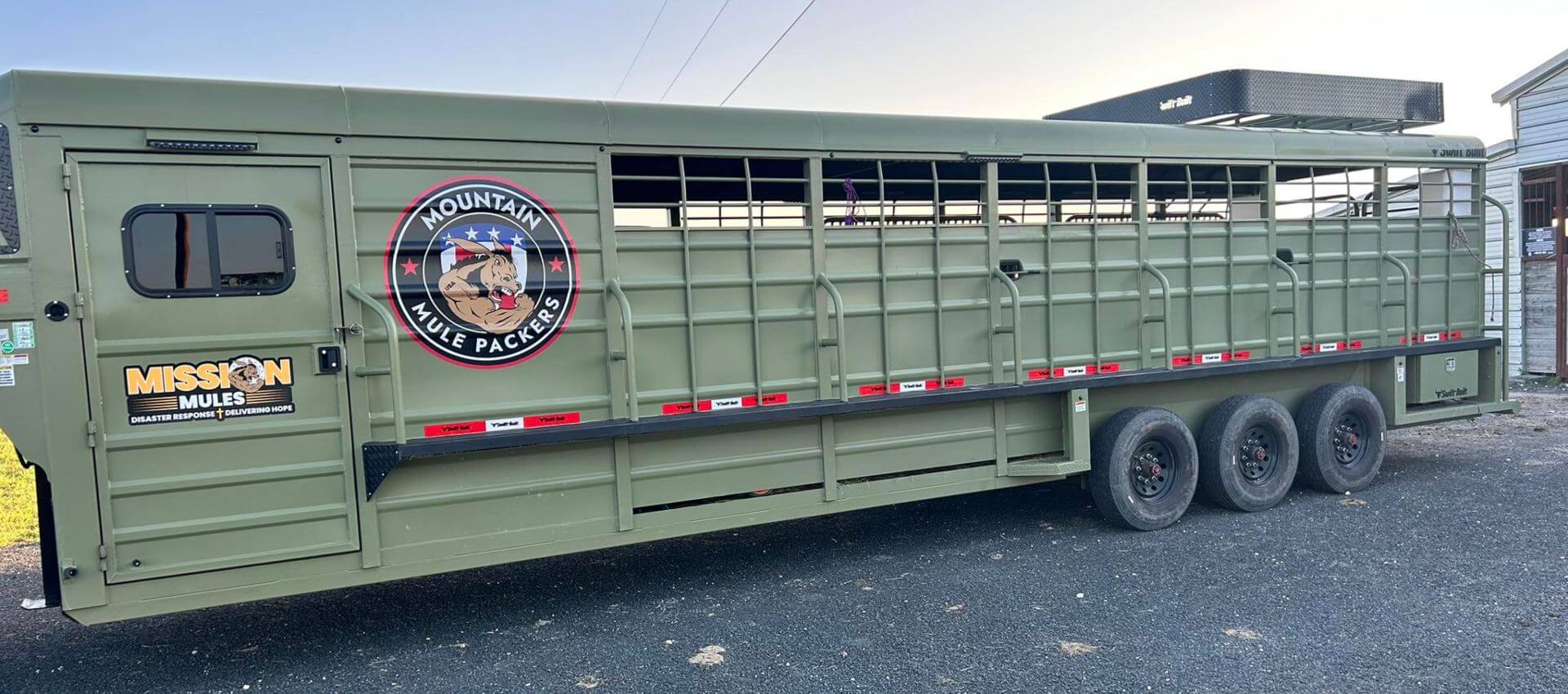 Long green horse trailer with Mission Mules and Mountain Mule Packers logos