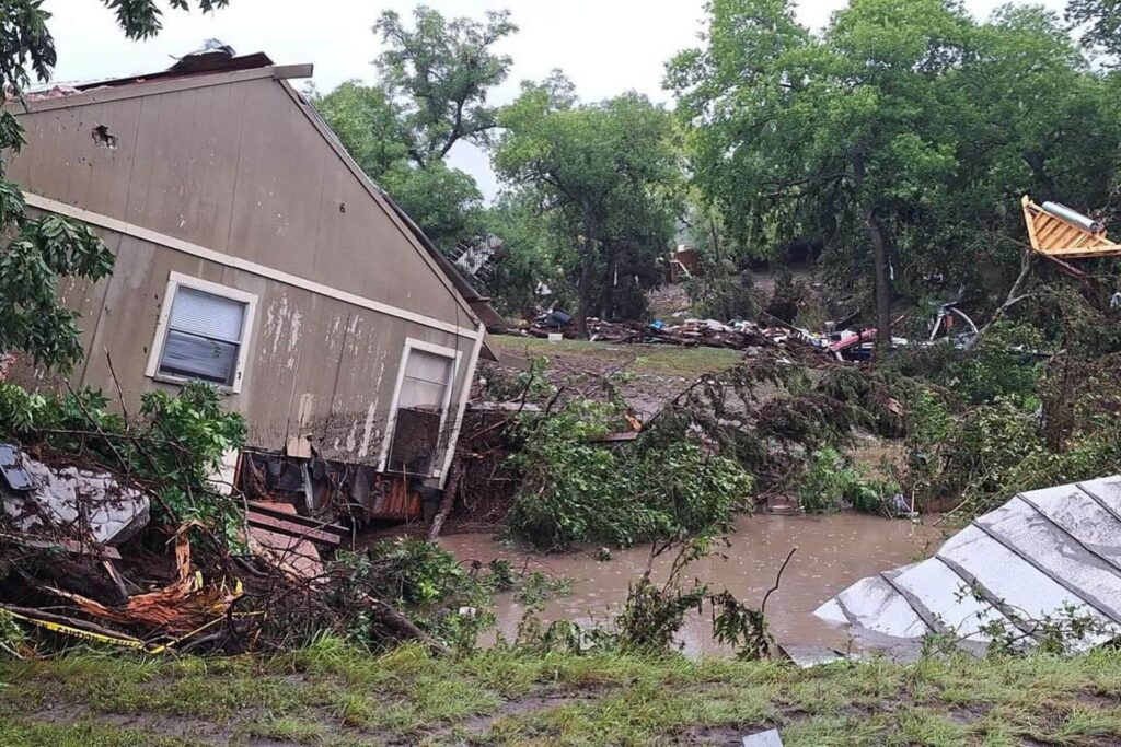 House destroyed laying sideways in a river