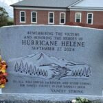 Mule standing next to granite memorial