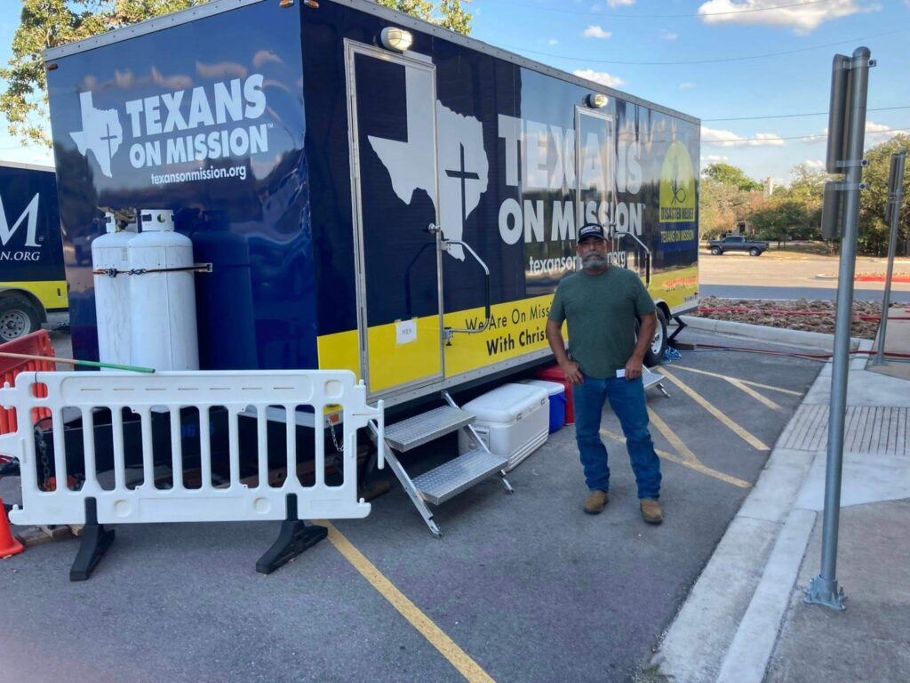 Man standing alongside a blue tractor trailer
